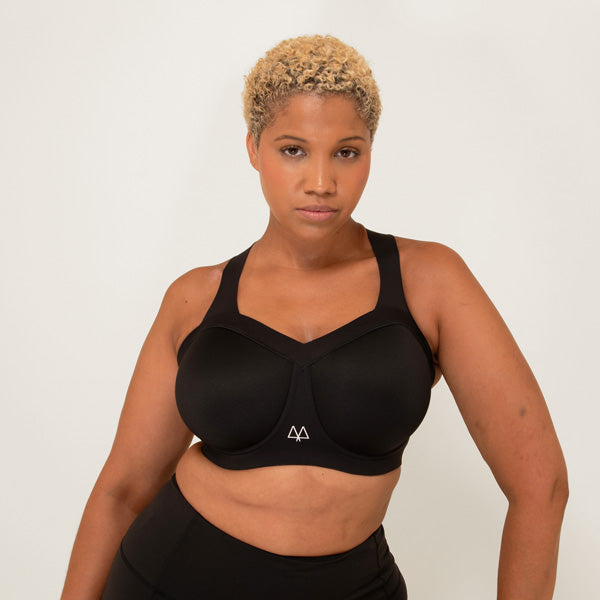 Person wearing a black sports bra and leggings on a white background