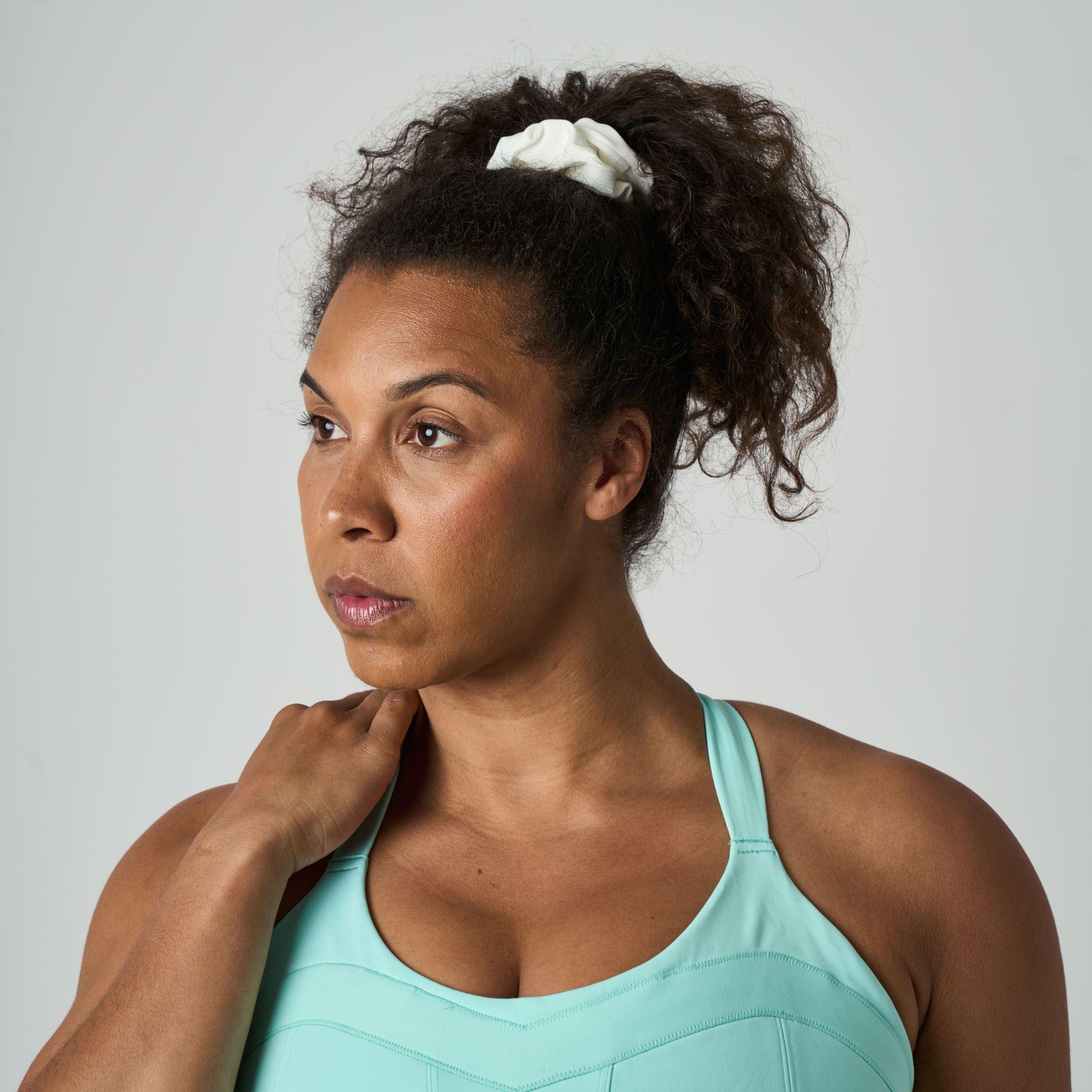 Woman wearing a light blue sports bra against a plain background