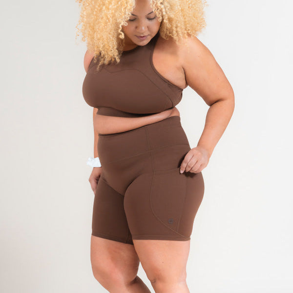 Woman wearing a brown athletic outfit on a white background