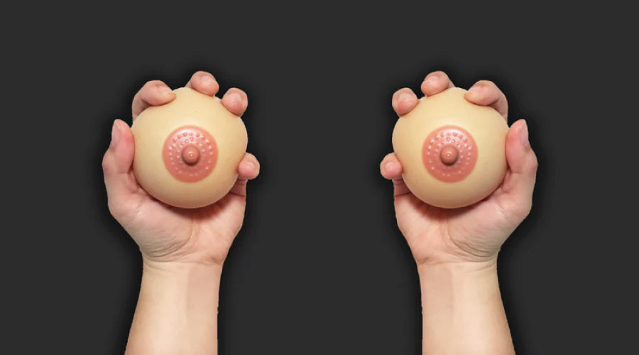 Pair of hands holding two stress balls against a black background