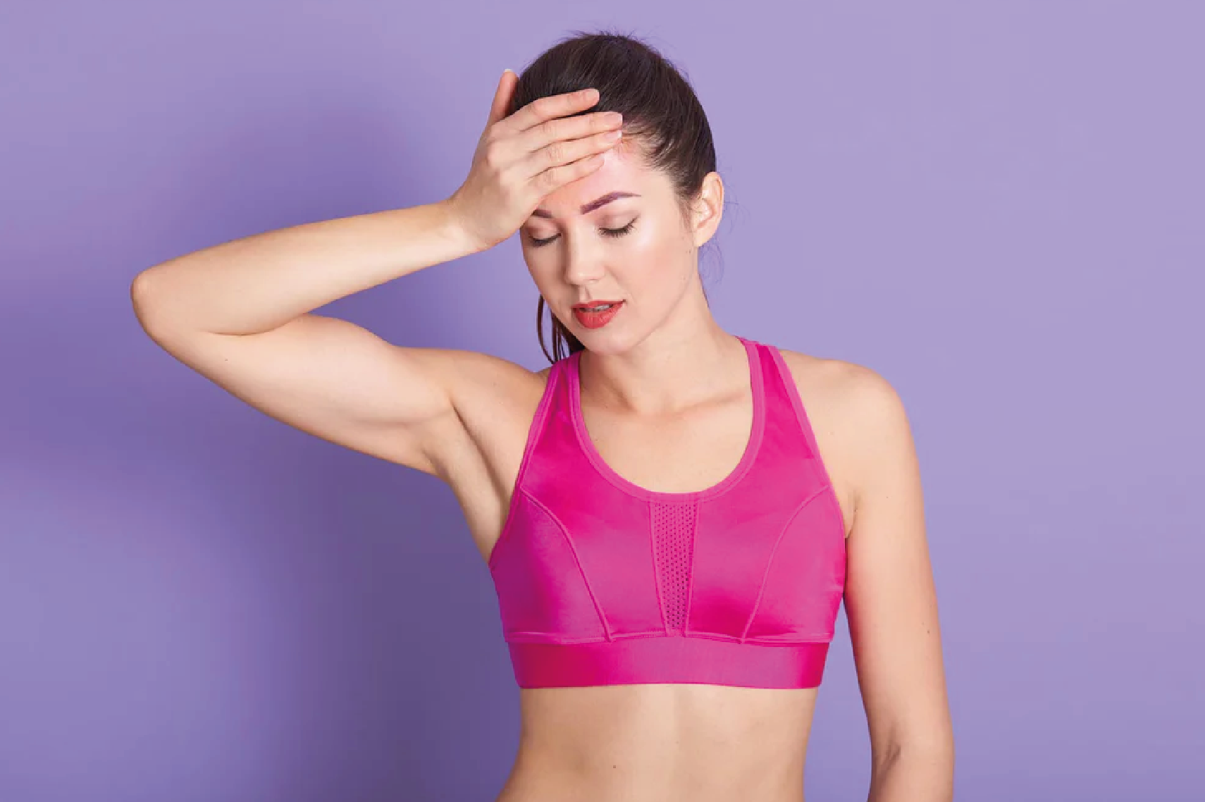 Hand on head in pink sports bra